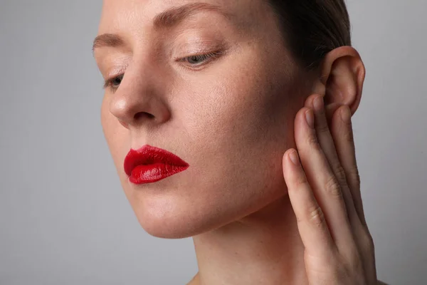 Close-up van jonge aantrekkelijke vrouw met ideale huid en rode lippen poseren indoor. — Stockfoto