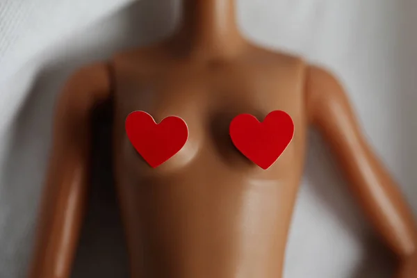 Detailní záběr na tělo panenky se dvěma červenými srdci na prsou. Koncept vztahu. — Stock fotografie