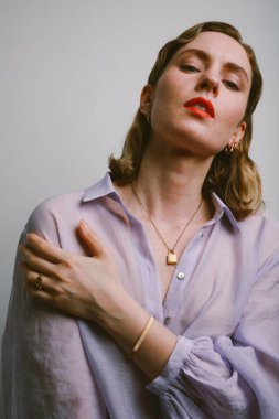 Senin düşüncen ne? Beyaz duvarda sakin ve gevşemiş yüz ifadesi olan kadın..