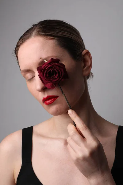 Молода жінка з сухою трояндою. Лікування проти старіння шкіри. Вертикальний . — стокове фото