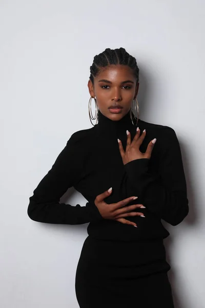 Cheerful African young woman with braids wears elegant dress posing indoor. — Stock Fotó