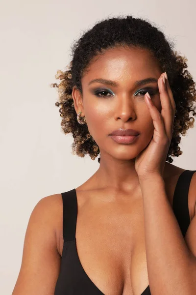 African American young woman is touching her face with hand. Vertical shot. — Photo