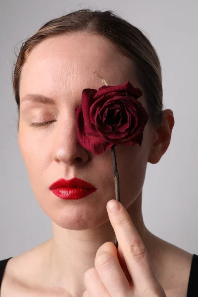Жінка середнього віку з сухою трояндою. Лікування шкіри проти агіту. Вертикальний . — стокове фото