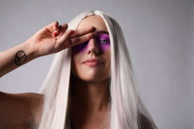 Yaratıcı makyajlı ve uzun sarı saçlı genç bir kadının portresi. İzole edilmiş.