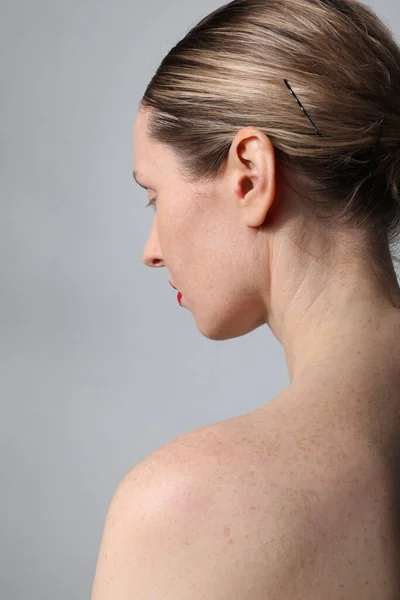 Close-up of young woman with perfect skin and red lips posing indoor. Back view. — Photo