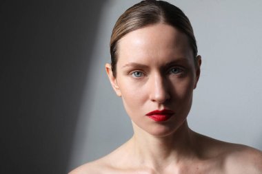 Portrait of beautiful young woman dark hair, blue eyes, neutral make-up. 
