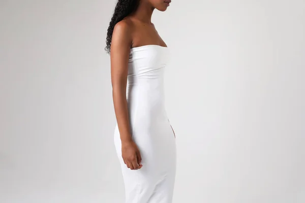 Mock-up av afroamerikanska kvinna bär vit klänning utgör inomhus. Isolerad. — Stockfoto