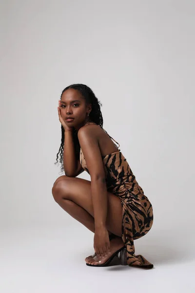 Κομψή Αφροαμερικανίδα ποζάρει στο στούντιο σε λευκό φόντο. — Φωτογραφία Αρχείου