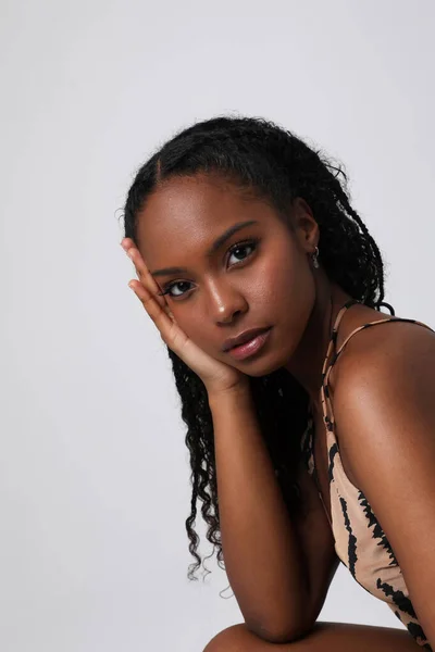 Mujer joven afroamericana con la cara tranquila y reflexiva posando en interiores. —  Fotos de Stock