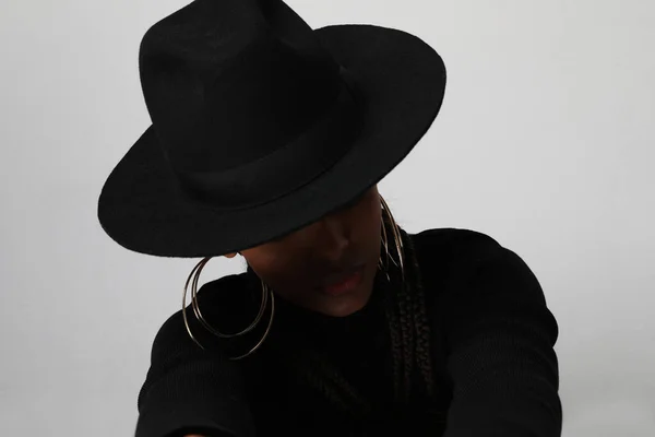 Портрет афроамериканской женщины в черной шляпе, позирующей на белом фоне. — стоковое фото