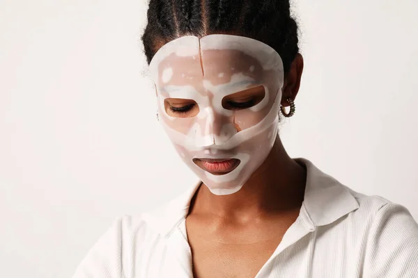 Young woman applies a hydro gel face mask. Skin care and beauty treatments — стоковое фото