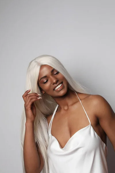 Ευτυχισμένη και αισιόδοξη Αφροαμερικανή με μακριά ξανθά μαλλιά. Κάθετη — Φωτογραφία Αρχείου