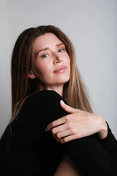 Positive young woman with natural make-up posing on white background. Vertical. — Stock fotografie