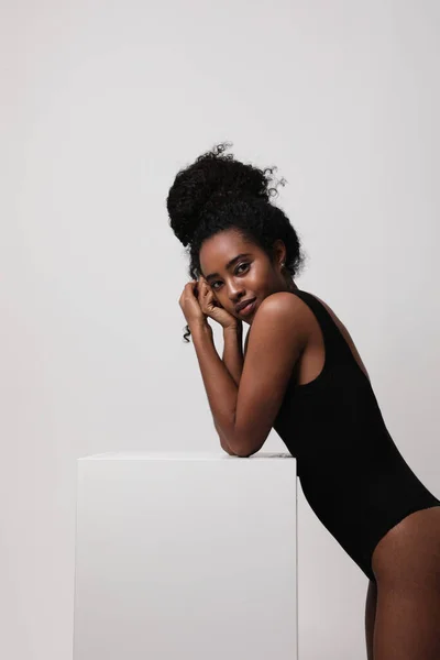 Mujer joven afroamericana positiva posa sobre fondo blanco. Vertical. — Foto de Stock