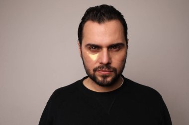 Kapalı alanda poz veren sakallı yakışıklı hippi. İzole edilmiş.