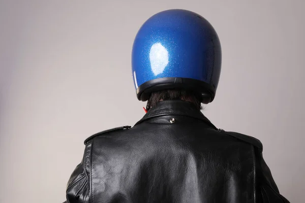 Pemandangan belakang pengendara motor berpose dengan helm biru di dinding putih. mock-up. — Stok Foto