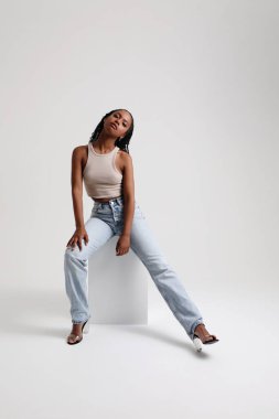 İyimser kadın stüdyoda poz veren günlük kıyafetler giyiyor. Dikey maket. Yüksek kalite fotoğraf.