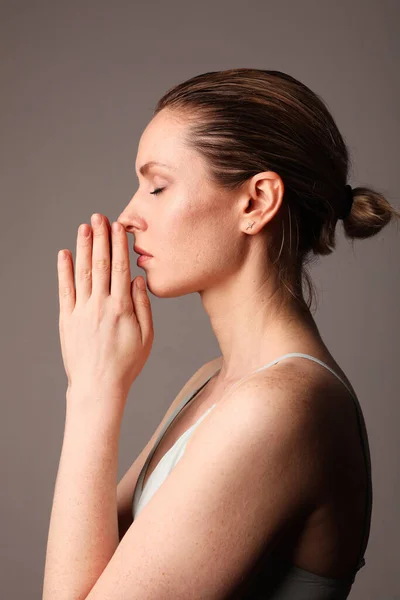 Yoga Femme Médite Avec Les Yeux Fermés Sur Fond Gris Image En Vente