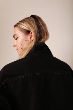 Stüdyoda poz veren siyah ceketli beyaz bir kadın. Model-up. Yüksek kalite fotoğraf.