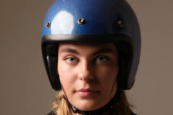 Close-up portrait of young woman wearing motor helmet poses indoor. Mock-up. High quality photo.