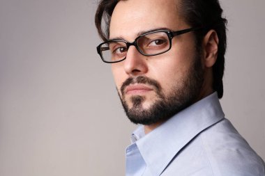 Close-up of young attractive business man standing in corporate portrait isolated on white background. High quality photo