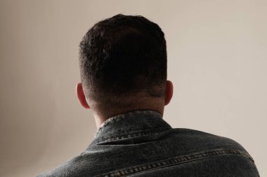 Kapalı alanda poz veren genç bir adamın yakın plan portresi. Model-up. Arka plan. Yüksek kalite fotoğraf.