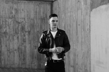 Yakışıklı, güler yüzlü, havalı hipster Lambersex modelinin siyah beyaz portresi. Moda erkeği sokakta poz veriyor. Dikey.