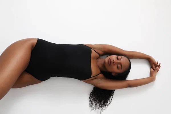 Wanita Muda Cantik Berbaring Latar Belakang Putih Mengenakan Setelan Tubuh — Stok Foto