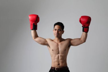 Asyalı boksör beyaz duvarın üzerinde eldivenlerini kaldırmış duruyor. Model-up. İzole edilmiş. Yüksek kalite fotoğraf.