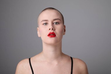 İçeride poz veren kameraya bakan genç ve güzel kel bir kadın. Model-up. Yüksek kalite fotoğraf.