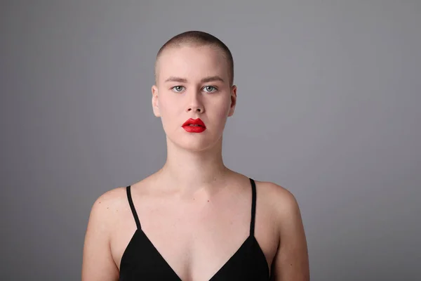 Young bald woman with serious face expression posing indoor. Mock-up. High quality photo.