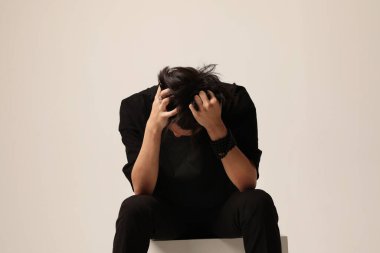 Stresli ve yorgun genç adam beyaz duvarda poz veriyor. Akıl sağlığı sorunları. Yüksek kalite fotoğraf.