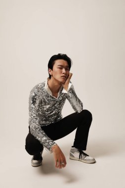 Beyaz arka planda poz veren kendine güvenen Asyalı genç bir adam. Dikey. Yüksek kalite fotoğraf.