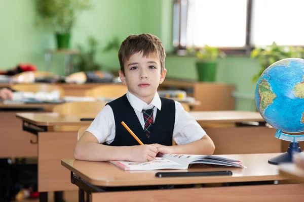 Uno Scolaro Siede Una Scrivania Con Libri Testo Sorrisi Vita — Foto Stock