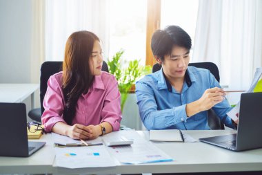 Pazarlık, analiz, tartışma, Asyalı erkek ekonomist yatırım finans programını şirket sahibine pazarlama ve iş risklerini önleme amaçlı olarak açıklayan bir belgeye işaret ediyor..