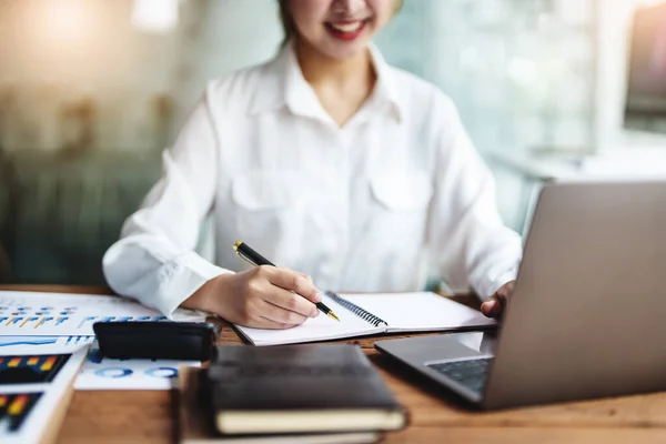 veri analizi, plan, pazarlama, muhasebe, denetleme, Asyalı iş kadını, pazarlama kalemini istatistiksel veri tablosu ve bilgisayarı kullanarak pazarlama projesini toplantıda sunmak için kullanıyor.