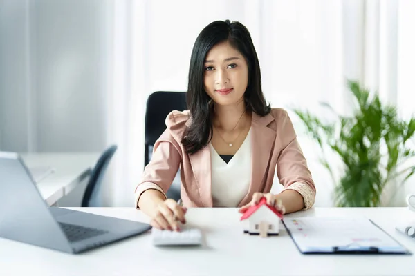 Empresarios, dueños de negocios, contadores, agentes inmobiliarios, Retrato de mujer asiática utiliza una calculadora para calcular su presupuesto casero para evaluar los riesgos de invertir en bienes raíces. — Foto de Stock