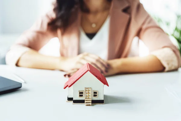 Planification, dépenses, en se concentrant sur le modèle de la maison avec le client qui prend des décisions sur l'achat d'une maison avec un agent immobilier pour gérer les risques financiers et de placement. — Photo