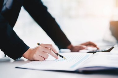 veri analizi, plan, pazarlama, muhasebe, denetleme, Asyalı iş kadını, pazarlama kalemini tutarken istatistiksel veri tablosu ve hesap makinesi kullanarak pazarlama projesini toplantıda sunar.