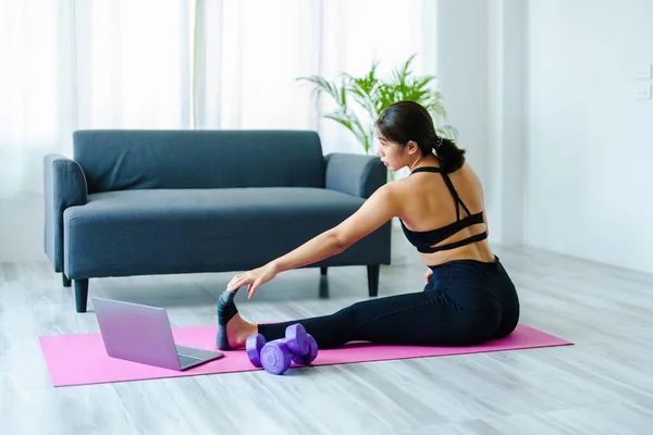 Stress relief, muscle relaxation, breathing exercises, exercise, meditation, portrait of Young Asian woman relaxing her body from office work by practicing yoga by watching online tutorials. — Stock Photo, Image