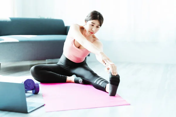 Stress relief, muscle relaxation, breathing exercises, exercise, meditation, portrait of Young Asian woman relaxing her body from office work by practicing yoga by watching online tutorials. — Stockfoto