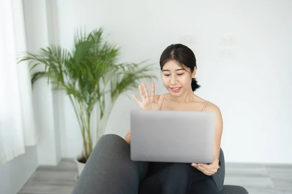 Uvolnění stresu, uvolnění svalů, dechová cvičení, cvičení, meditace, portrét mladé asijské ženy, která uvolňuje své tělo z kancelářské práce cvičením jógy sledováním online tutoriálů. — Stock fotografie