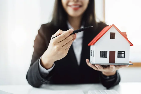 Law, agreement, contract, mortgage, woman holding a pen, pointing at a house to see the interest rate and asking for the limit to assess the risk before buying a house — Photo