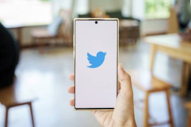 CHIANG MAI, THAILAND - 13 Mayıs 2022: Twitter logolu akıllı telefon taşıyan kadınlar. Twitter, mikroblog ve ağ iletişimi için bir sosyal medya hizmetidir.