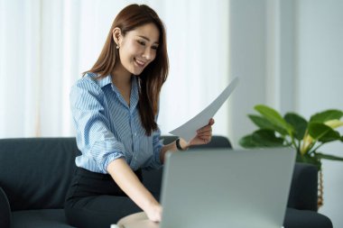 Serbest meslek sahibi, iş sahibi, işten zevk alan Asyalı kadın portresi, finansal belgeleri kullanarak bütçeyi kontrol eden veya planlayan, evdeki yatırım riskini yöneten.