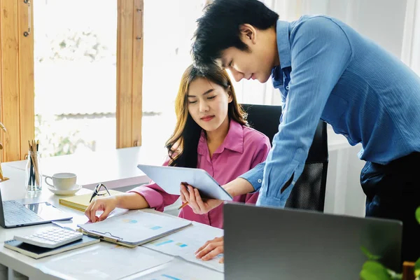 Negotiation, analysis, discussion,asian male economist using tablet explaining the investment finance program to the company owner to plan marketing and hedging business risks. — Stockfoto