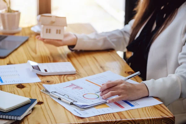 Femme asiatique comptable, femme d'affaires, agent immobilier, tenant un stylo, pointant vers le prêt à domicile et les documents d'intérêt pour calculer le risque dans le budget d'investissement à domicile. — Photo
