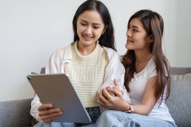 Igbtq, Igbt konsepti, homoseksüellik, iki Asyalı kadının tablet kullanırken birbirlerini sevdiklerini gösteren portresi.