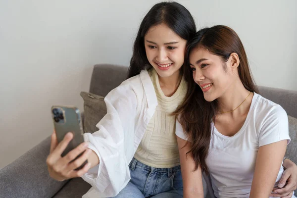 Lgbtq, koncepcja lgbt, homoseksualizm, portret dwóch azjatyckich kobiet bawiących się razem i okazujących sobie miłość podczas używania smartfona do robienia selfie — Zdjęcie stockowe