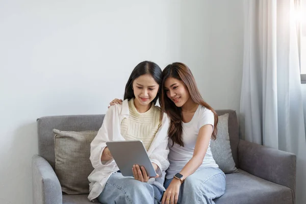 Lgbtq, koncepcja lgbt, homoseksualizm, portret dwóch azjatyckich kobiet bawiących się razem i okazujących sobie miłość podczas używania tabletu — Zdjęcie stockowe